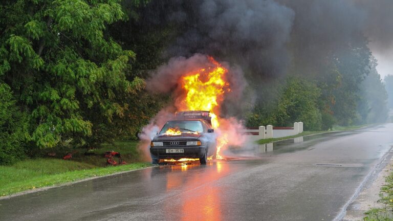 Image of a car engulfed in flames after a mechanical failure, highlighting the risks of automobile defects