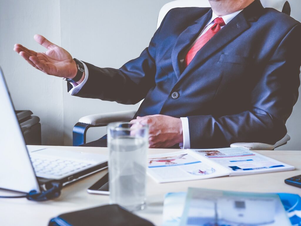 Man seated behind a desk in a supervisory role, symbolizing a boss potentially violating California wage and hour law by not adhering to the state's requirements.
